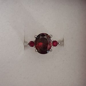 Silver Toned Ring With Oval Cut Deep Red Gemstone